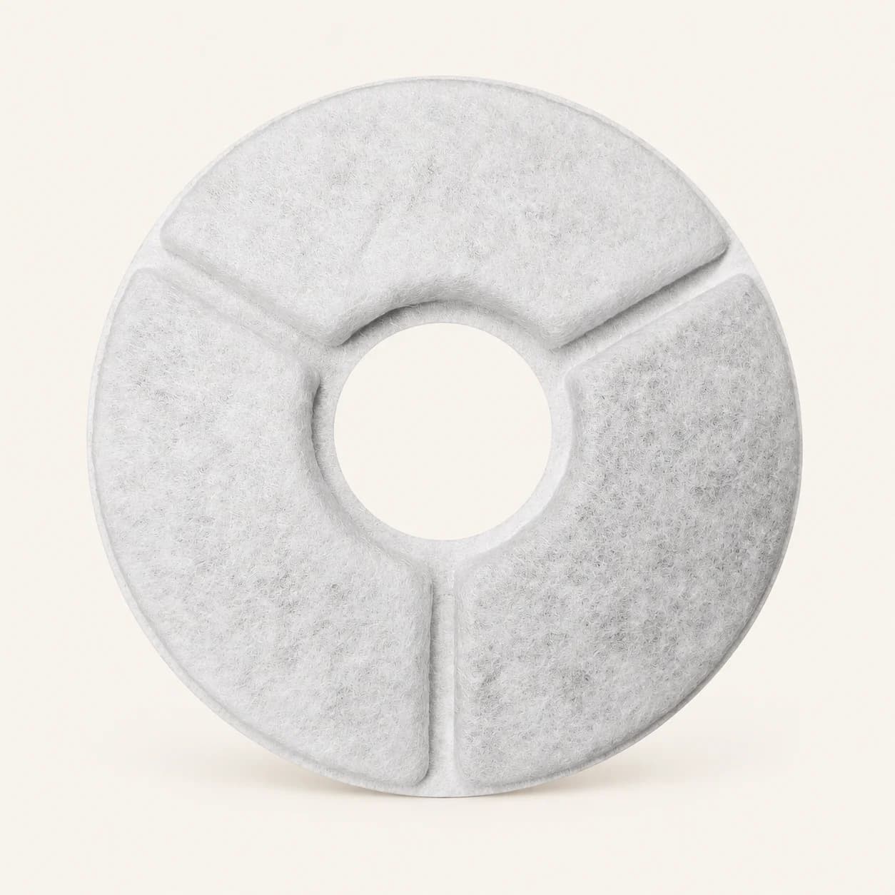 Detail of one white circular Mizusu fountain filter; pack contains four filters and four pump sponges